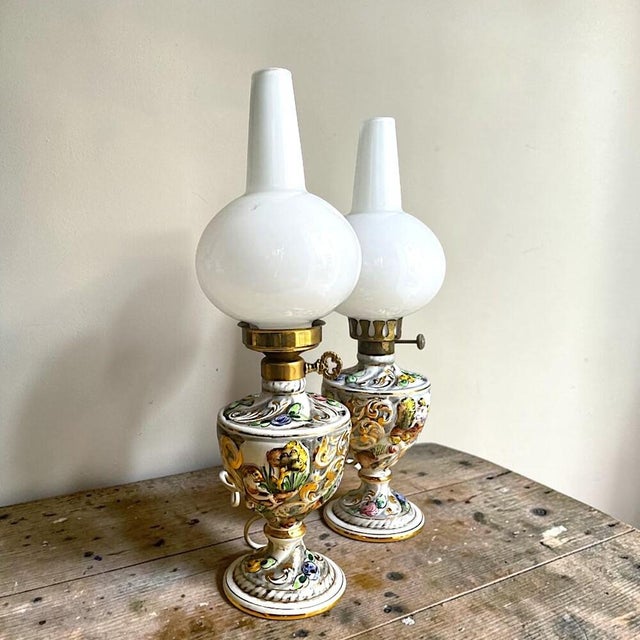 This pair of hand-painted porcelain table lamps was crafted in portugal by the renowned alcobaça porcelain factory...