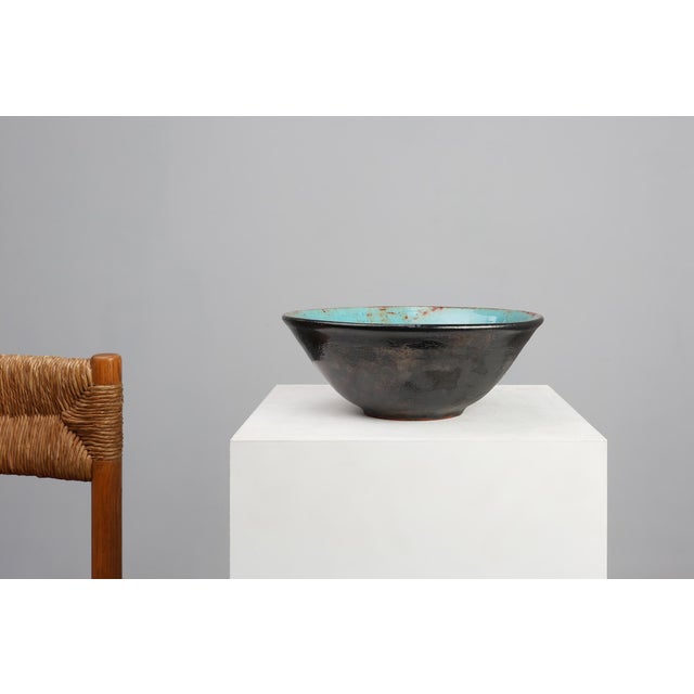 A captivating ceramic bowl from Belgium, crafted circa 1960 by the renowned Perignem atelier, an emblem of postwar...