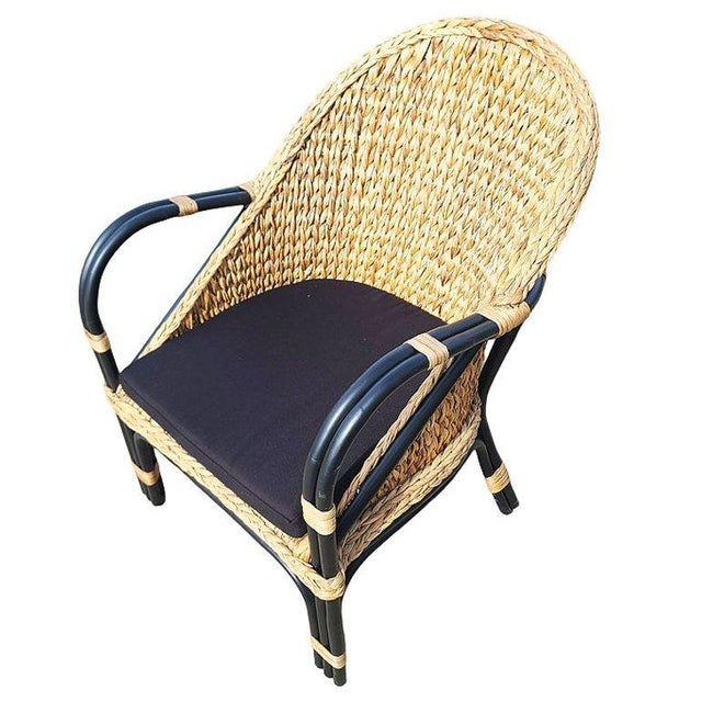 Revamp your dining area with this elegant black rattan armchair/dining chair, boasting a natural wicker fan seat and a...