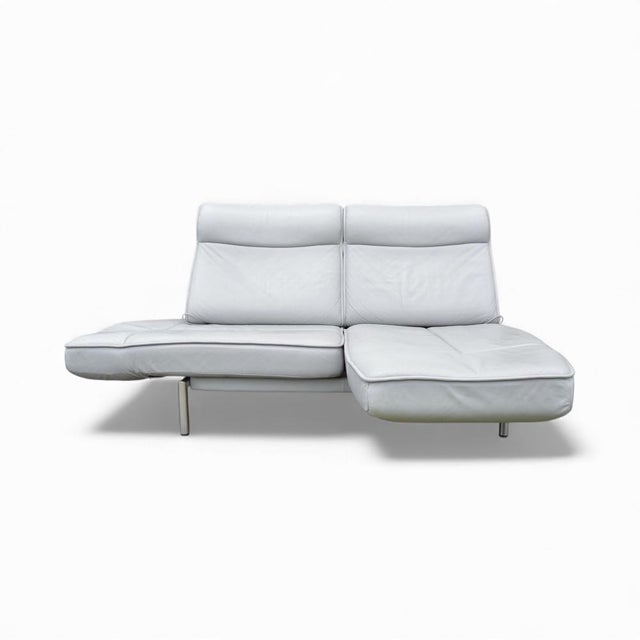 Versatile sofa with adjustable backrests and fold-out armrests. Polished stainless steel base.