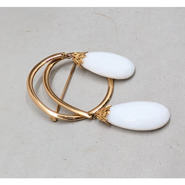 1960s goldtone loop with two faceted white resin teardrop shaped rhinestone drops brooch with security clasp. Marked...