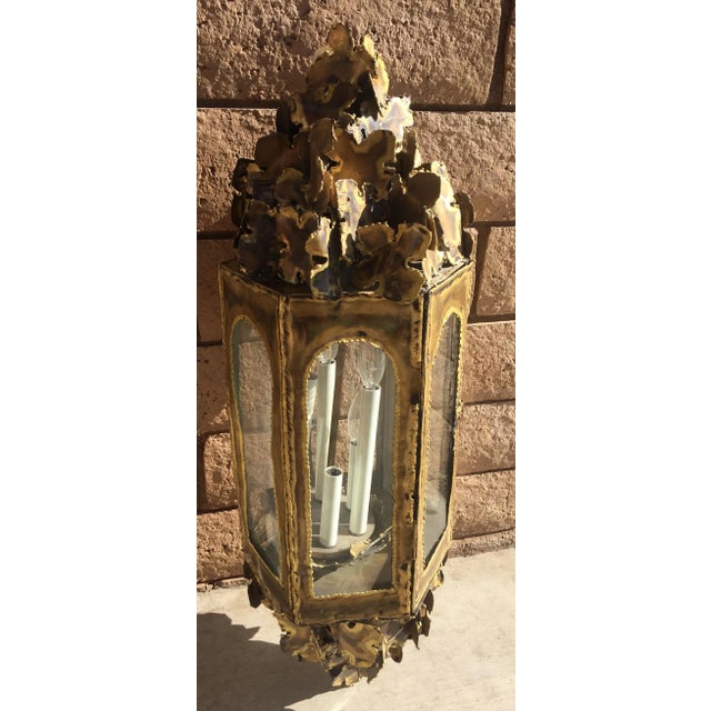 Mid-century brutalist brass lantern pendant by Tom Greene. Lighting features six staggered candlestick lights with hand-...