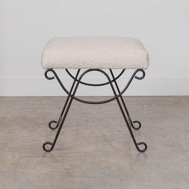 Iron stool with beautiful curved and looped base with matte black painted finish. Rectangular cushioned seat upholstered...