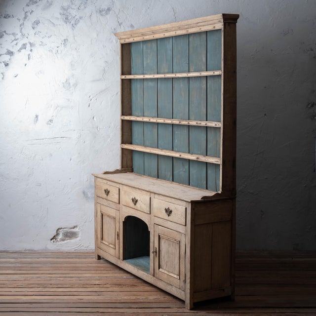 A Welsh oak dog kennel dresser, c.1800, bleached finish with a painted backboard, open plate rack, and lower case fitted...