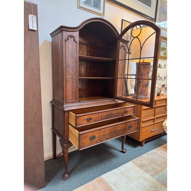 Design Plus Gallery presents an Antique Mahogany China Cabinet in the Queen Anne Style. The cabinet has a tall base that...