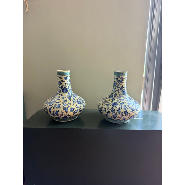 Pair of blue and white porcelain hand-painted vases featuring detailed floral and foliate motifs throughout. Each vase has...