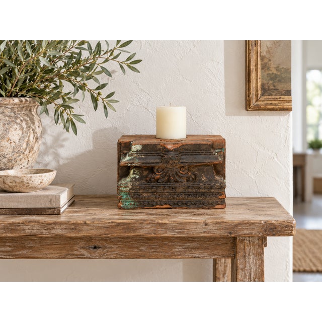 The front is a study in layers. Moldings stack one above the other, a band of scrolls and leaves sits at the center and a...