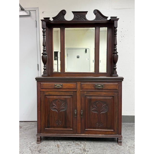 Design Plus Gallery presents a Victorian Carved Mahogany Triple Mirror Sideboard. This antique sideboard presents a grand...