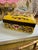 A striking chinoiserie porcelain lidded box finished in a richly saturated imperial yellow ground, adorned with finely...