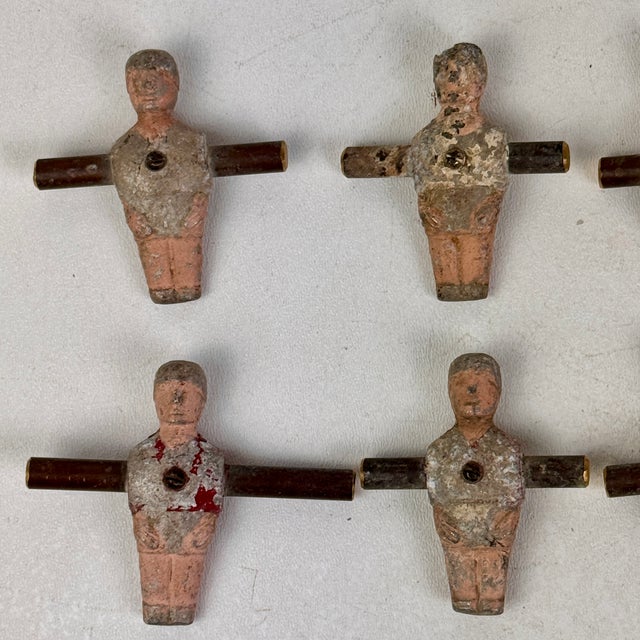 A set of 10 salvaged football soccer players made of metal with what seems to be brass bar that connected them. These came...