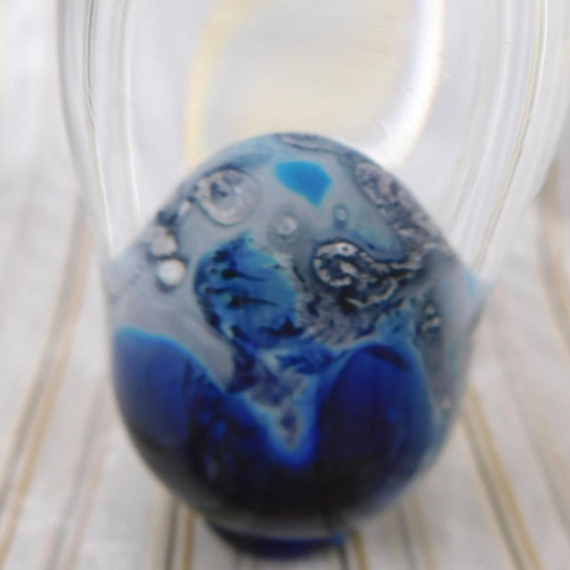 This is a hand blown blue and white art glass perfume bottle. It is signed as shown. It has a very sedate blue and white...