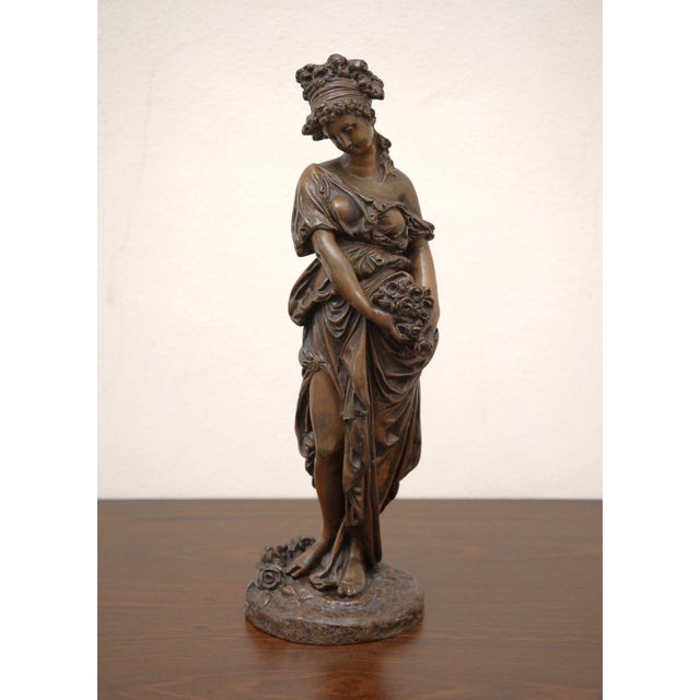 A high-quality bronze statue of a young woman in an allegorical concept, depicting the personification of spring. The...