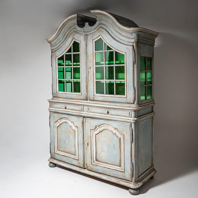 Solid oak display cabinet with a two-door glazed upper section and a two-door lower cupboard. The shaped crest, molded...