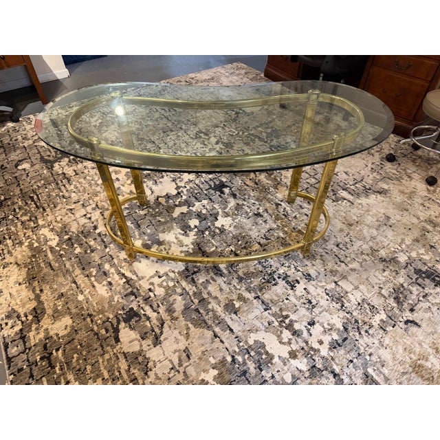 Bring an air of sophisticated glamour to your workspace with this striking vintage Hollywood Regency writing desk....
