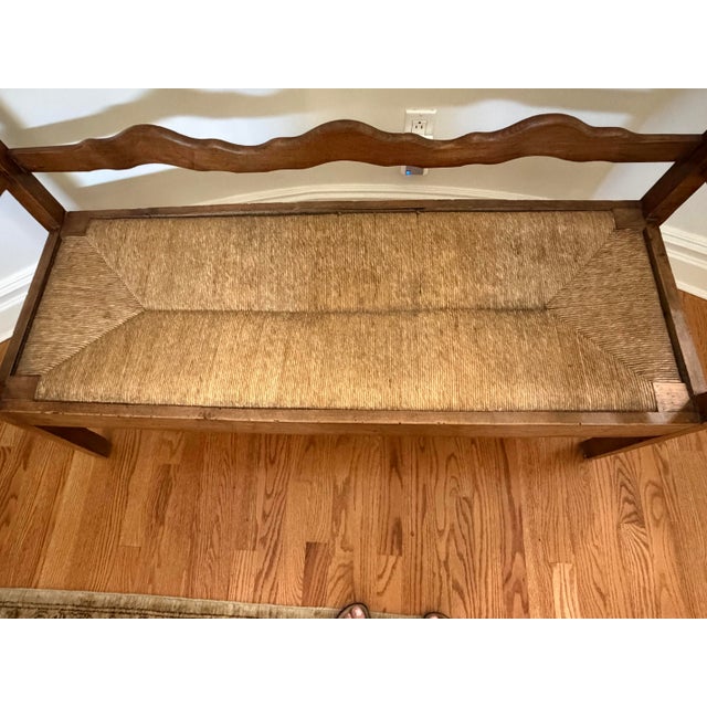 Rustic bench with unusual wave back support and rope rush seat.