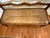 Rustic bench with unusual wave back support and rope rush seat.