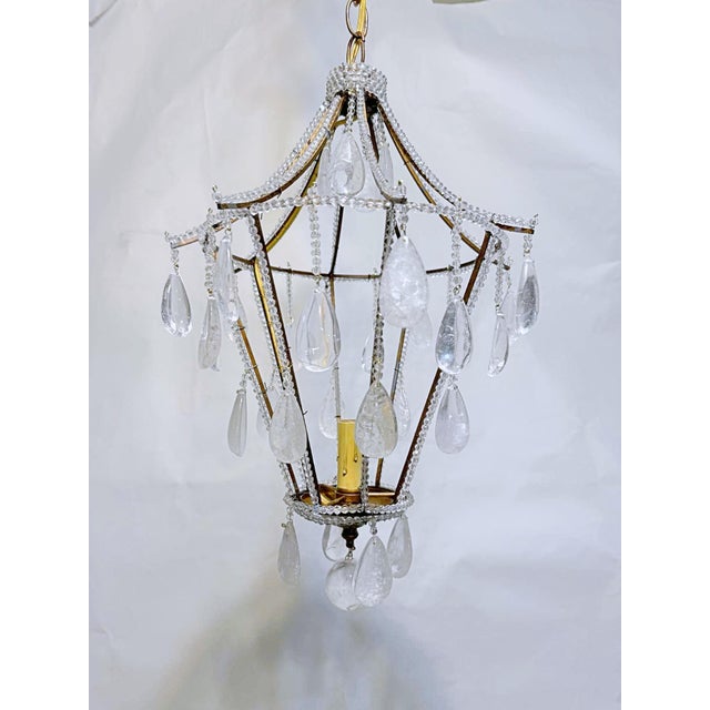 Vintage French chandelier with brass frame and dressed with hand cut natural rock crystals. It has one candelabra base...