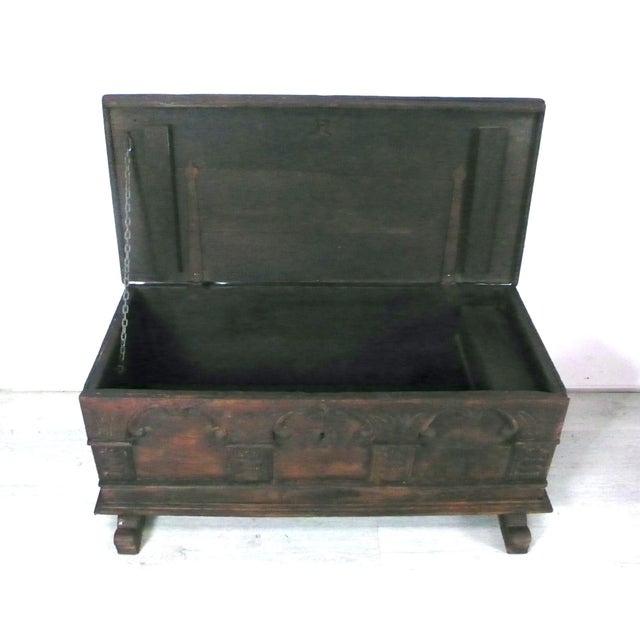 Antique chest with a flat lid in a casket style. It is made of heavy oak. The front is decorated with rounded arches,...