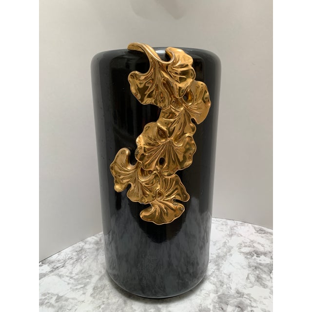 Vintage glossy black and gold Italian vessel or vase with draped textural gold ginkgo flowers bursting over one side....