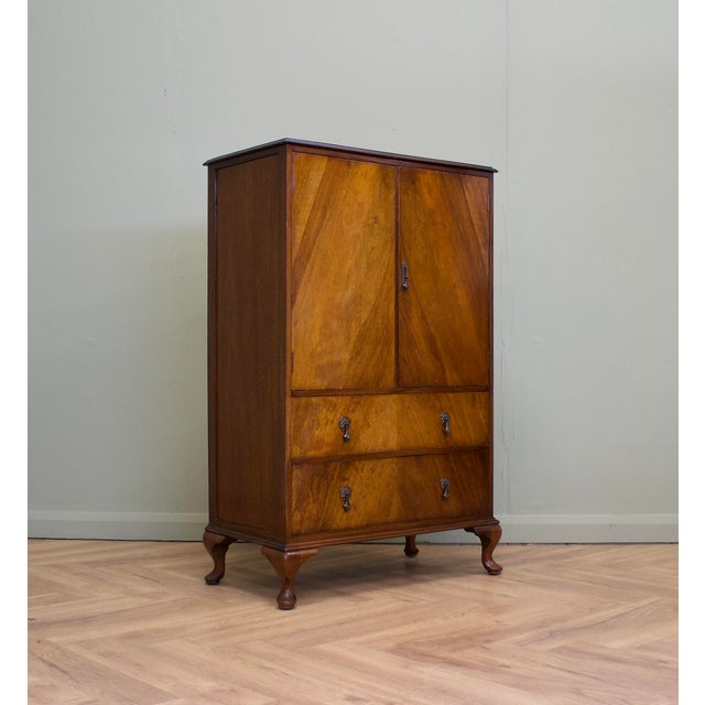 A compact 1930s walnut tallboy linen cupboard by renowned British furniture maker Waring & Gillow. Featuring figured...