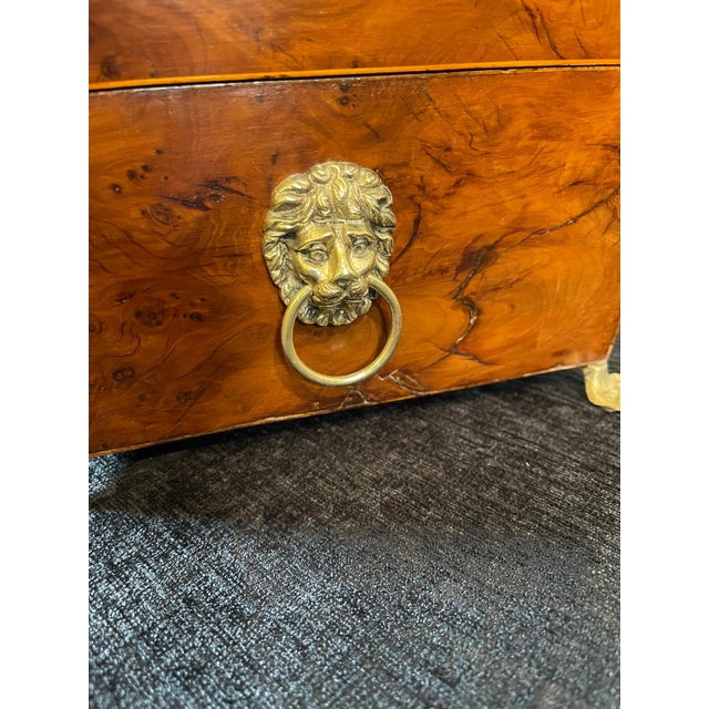 Regency birdseye maple sewing box with lions heads handles on each side & lions hairy paw feet with a key.