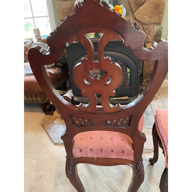 Timeless and stately, this pair of Victorian parlor chairs showcases hand-carved mahogany frames with rich floral tapestry...