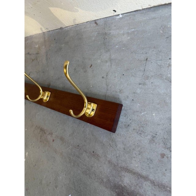 Minimalist Danish Mid Century Modern wall coat rack crafted from solid teak wood. This elegant piece features a clean...