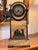 19th century French mantel clock in an arched case of warm yellow veined marble with dark patinated mounts. A scaled band...