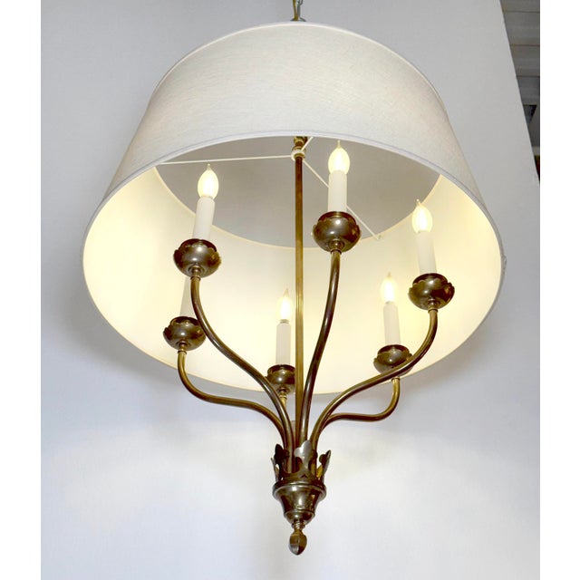 Traditional style brass chandelier paired with a white drum shade. This light requires six standard Edison style medium...