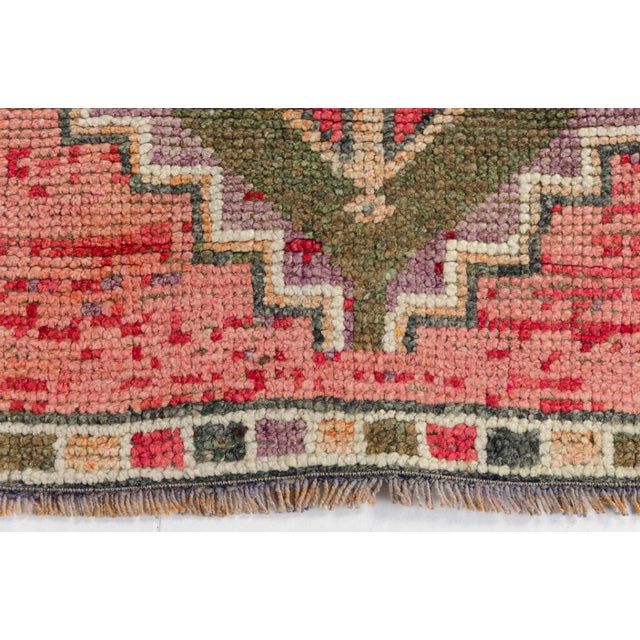 This is a vintage Turkish Oushak rug from the Mid 20th Century. The piece was hand-knotted.