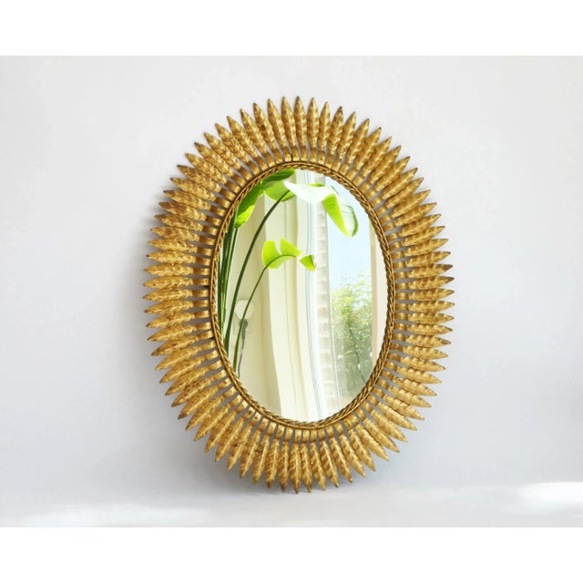 A vintage gold gilt metal sun mirror made in Italy. The wall mirror has an oval shape and has a beautiful frame. Large in...