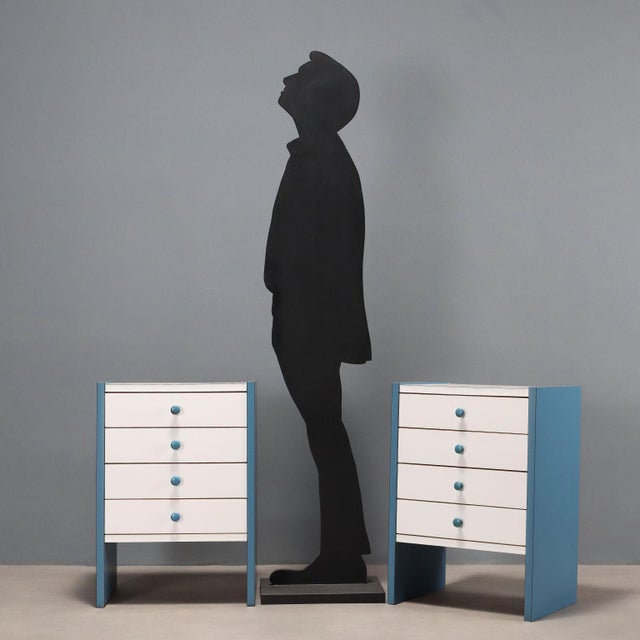 Pair of vintage bedside tables with four drawers in two-tone laminated wood in shades of white and air force blue. This...