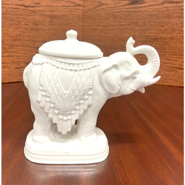 An Asian style candy dish in the shape of an elephant by Andrea by Sadek. Hand painted, white in color glazed porcelain of...