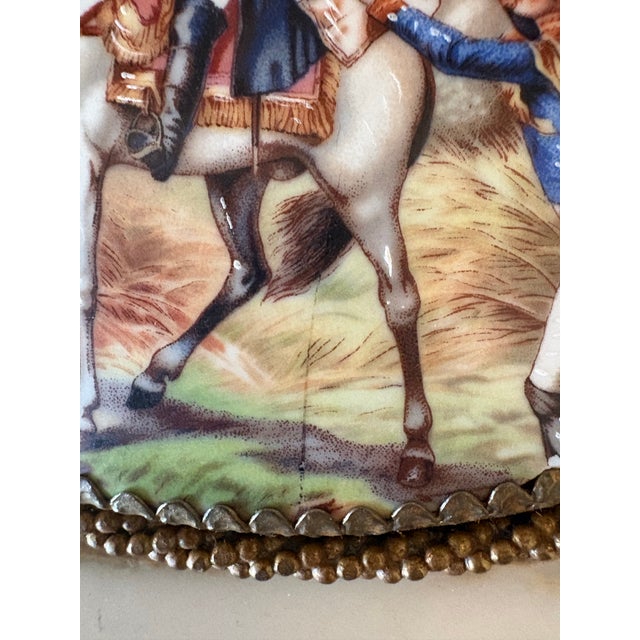 A pair of porcelain plaques color transfer with hand embellishments of Napoleon on horseback in battle. Each is trimmed in...
