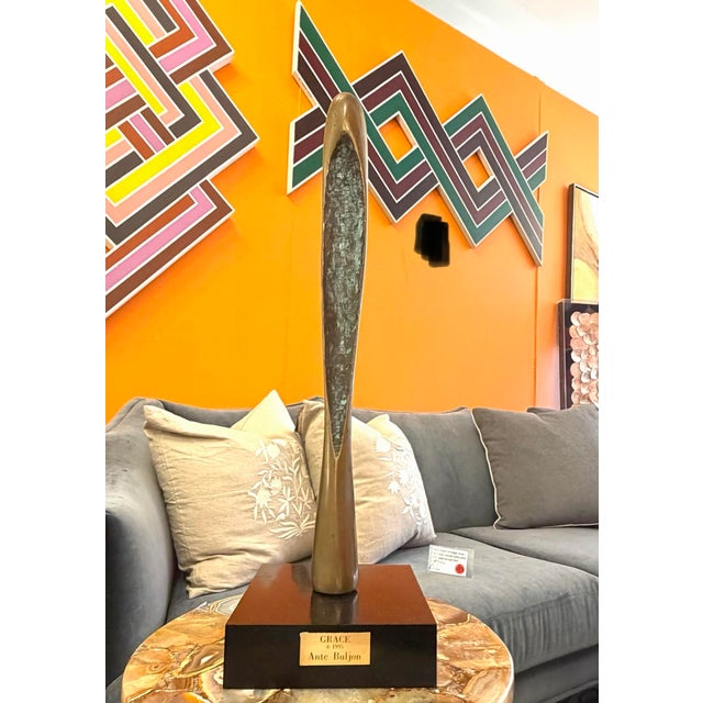 Tall bronze abstract modernist sculpture. Mounted on stone base and has a brass plate with the artists name, date and...