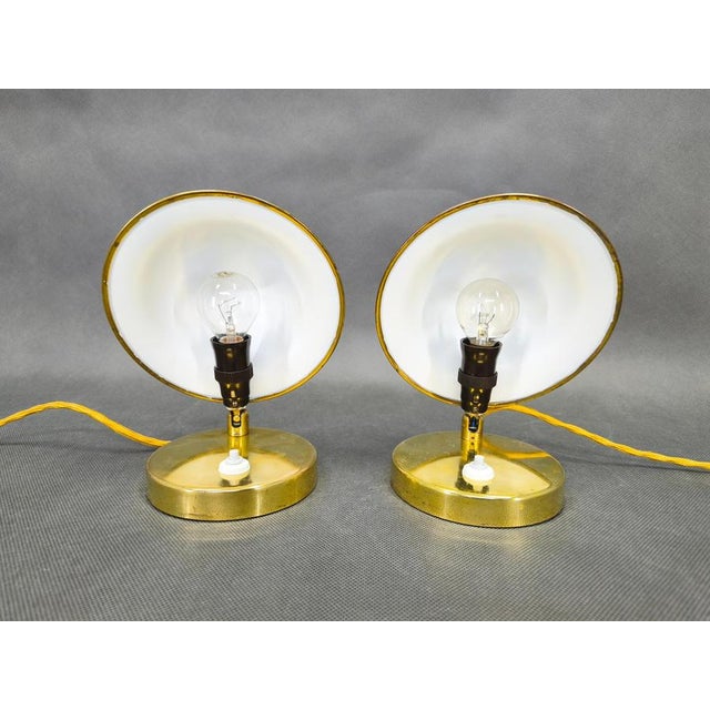 A rare pair of art deco table lamps from 1930s czechoslovakia. Crafted from brass plated metal, these lamps feature a...