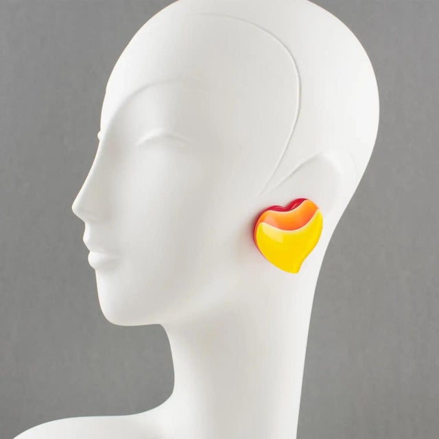 These lovely Lucite clip-on earrings feature a large carved heart shape with lamination. The bright red background is...
