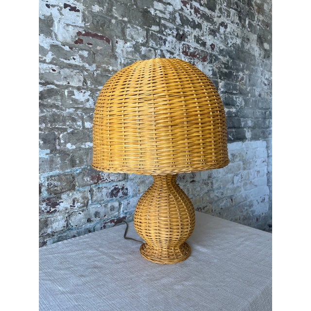 Bring warmth and natural texture into your space with this beautifully sculpted vintage rattan table lamp. Featuring a...