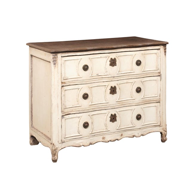 A French Neoclassical painted serpentine commode from the 18th century. This antique chest from France has a ruffled...