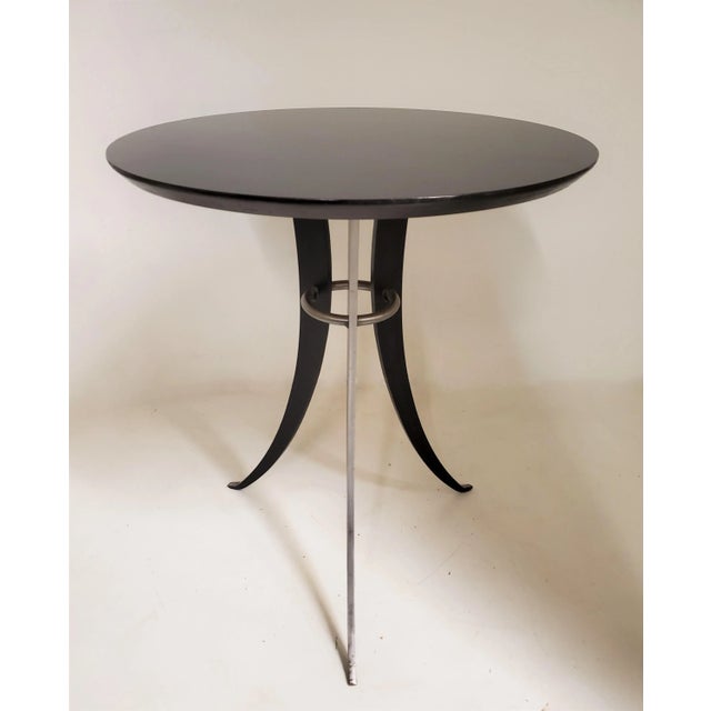 A Minimalist pair of tulip design, splay leg end tables in steel and lacquered wood. The austere and streamline design...