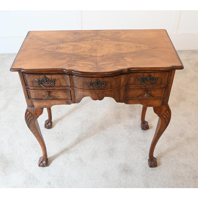 A handsome walnut lowboy in the Queen Anne style, dating to around 1890 The shaped top displays beautifully figured walnut...