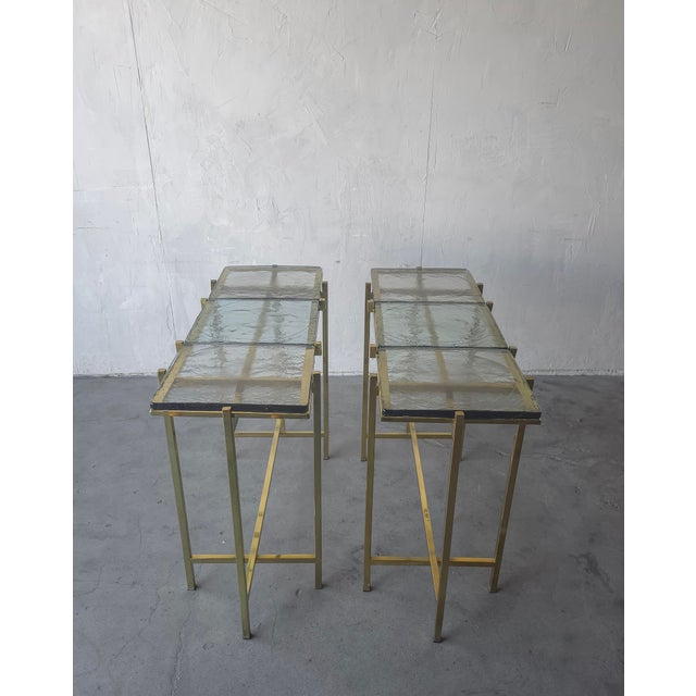 This is a stunning pair of custom brass and cast glass console tables. The thin, architectural lines of the tube brass...