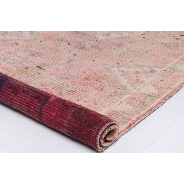 This is a vintage Turkish Oushak rug from the Mid 20th Century. The piece was hand-knotted.