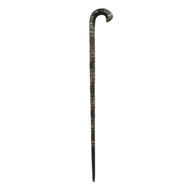 Old walking stick cane in dark wood, possibly rosewood with alternating twisted wood and mother of pearl inlay showing...