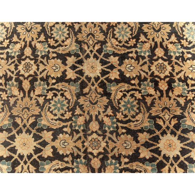 An early 20th century Kirman (Kerman) antique carpet from Southeast Persia on a black field with an overall herati pattern...