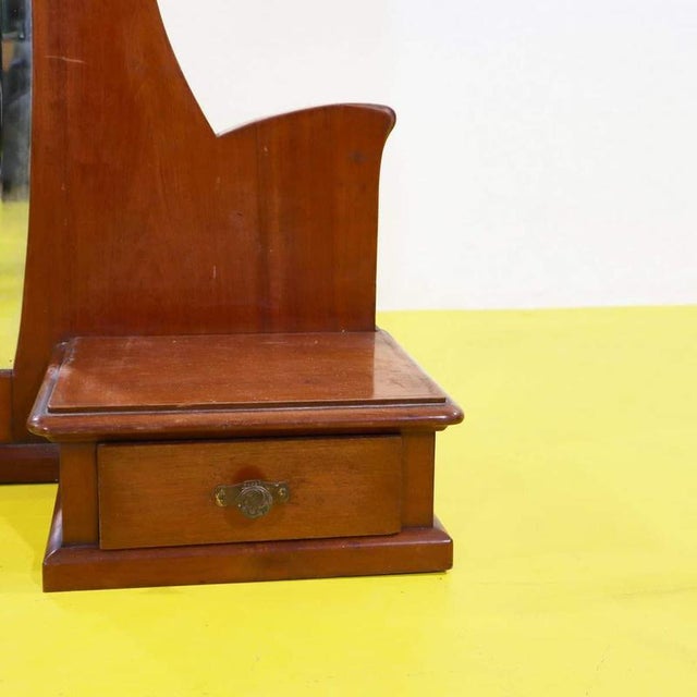 Wooden polished mirror featuring two side drawers.