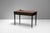 Two drawer writing table in walnut with brass mouldings and original ebonised finish. Circa 1940.