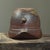Stoneware, anagama wood–fired. The surface exhibits natural ash deposits and variable texturing consistent with extended...