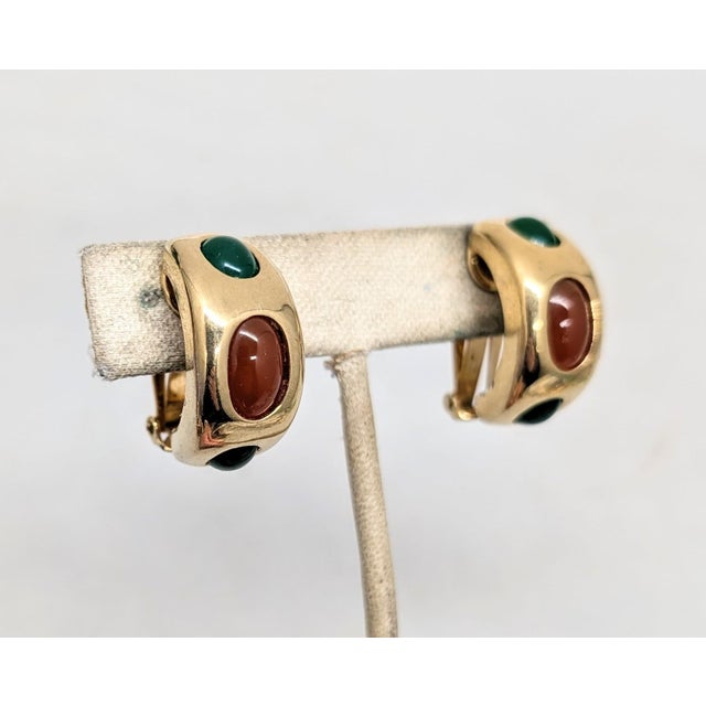 1960s goldtone central oval cabochon faux-carnelian with two oval cabochon faux-jade rhinestones on top and bottom clip...