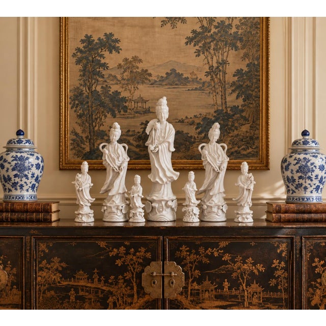 A serene grouping of seven blanc de chine figures depicting Quan Yin, the bodhisattva of compassion, rendered in softly...